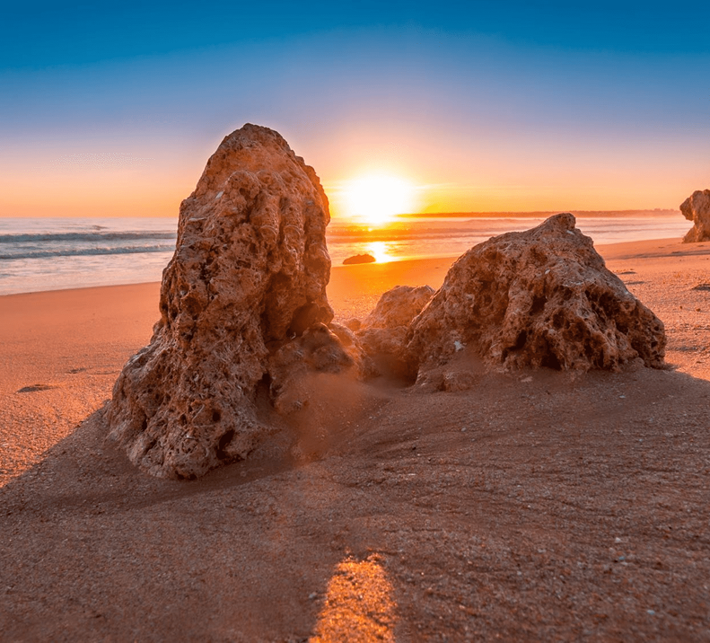 Formações rochosas numa praia do Algarve ao pôr do sol